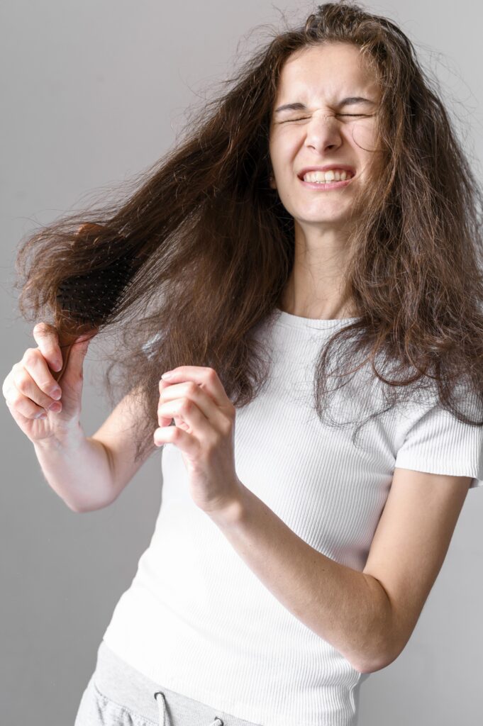 Woman struggling to brush hair.